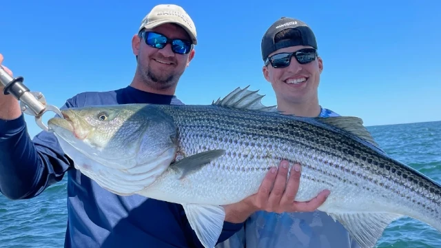 Two men holding a fish they caught