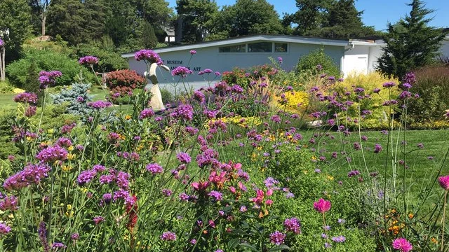 An outdoor view of the Ogunquit Museum of American Art with flowers in the foreground.