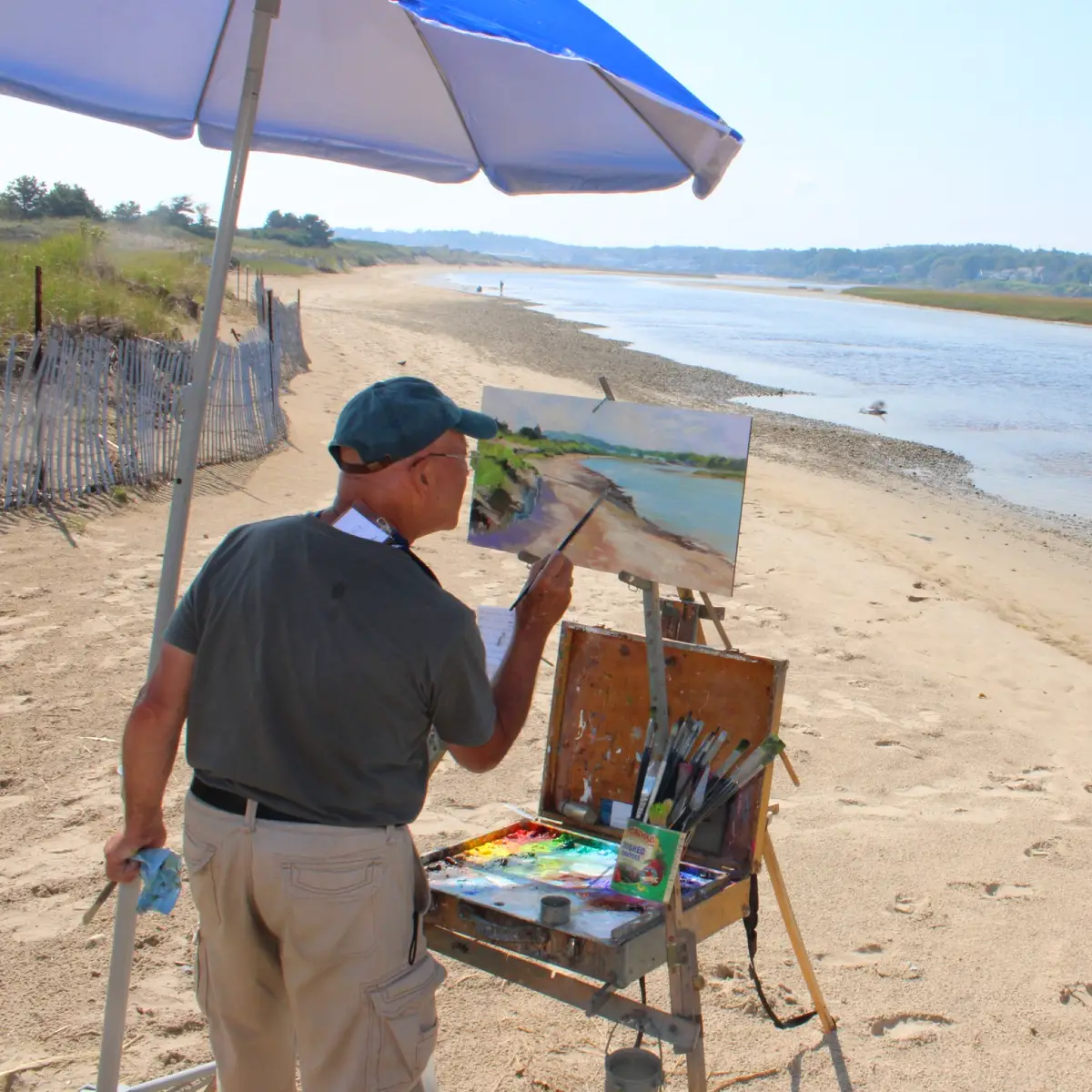 A man painting on the banks of the Ogunquit river.