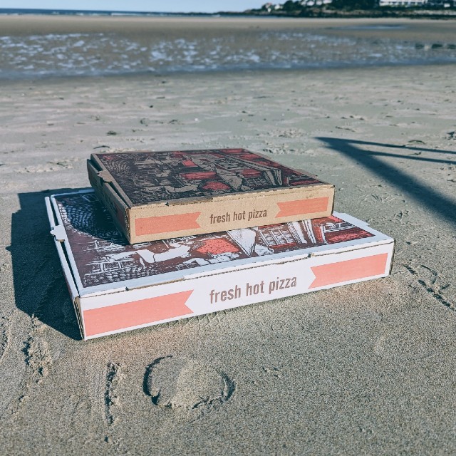 Pizza boxes sitting on the sand at Ogunquit beach