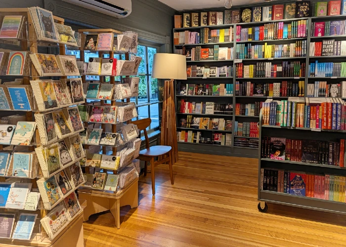 A yellow store with a sign that says Spoiled Rotten and a blooming tree in the background