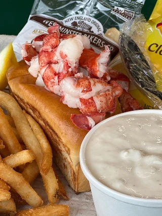 A lobster roll with french fries and chowder