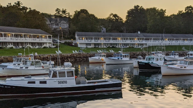 A view of Perkins Cove with boats and a hotel in the background.