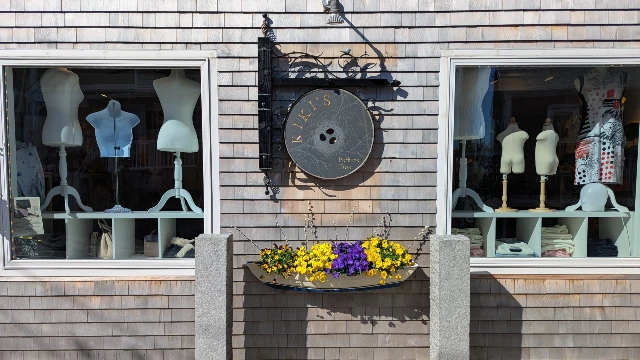 Photo of the front of Kiki's showing two window displays with mannekins.